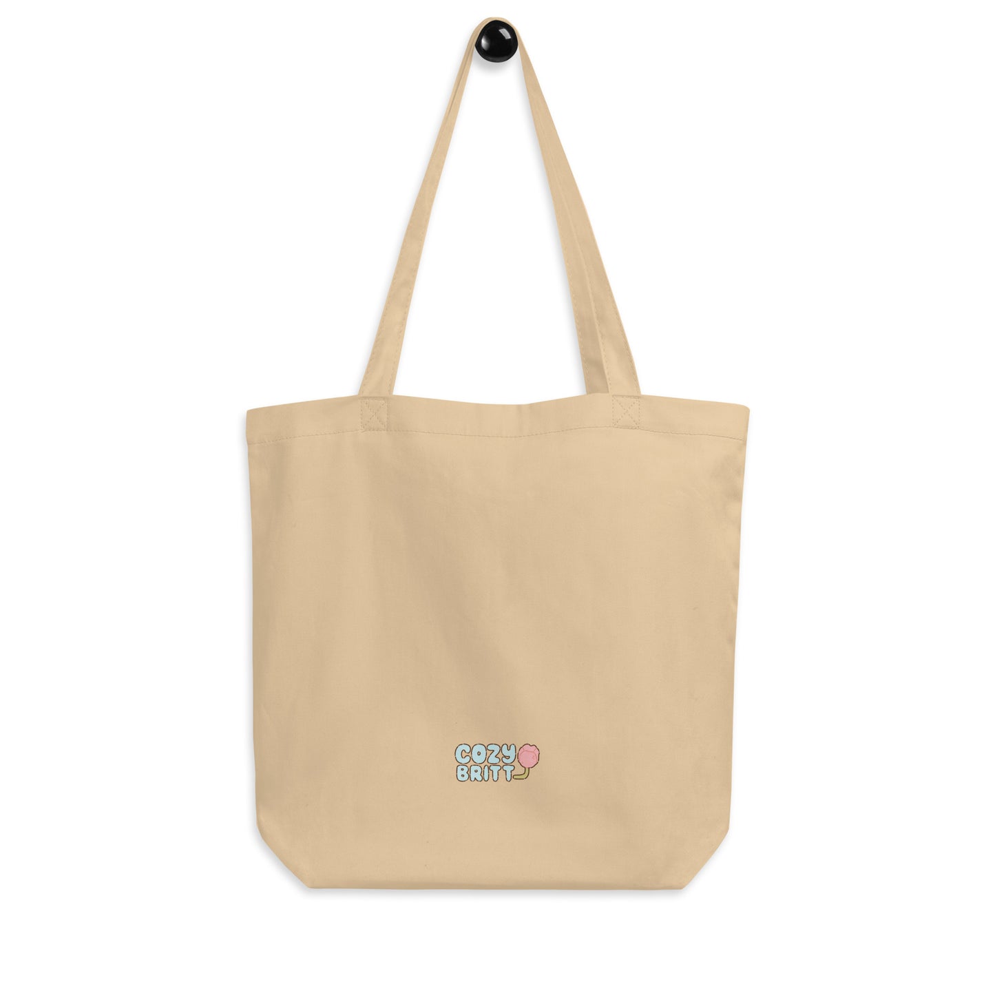 Beige tote bag with 'Cozy Girl' embroidery on a white background
