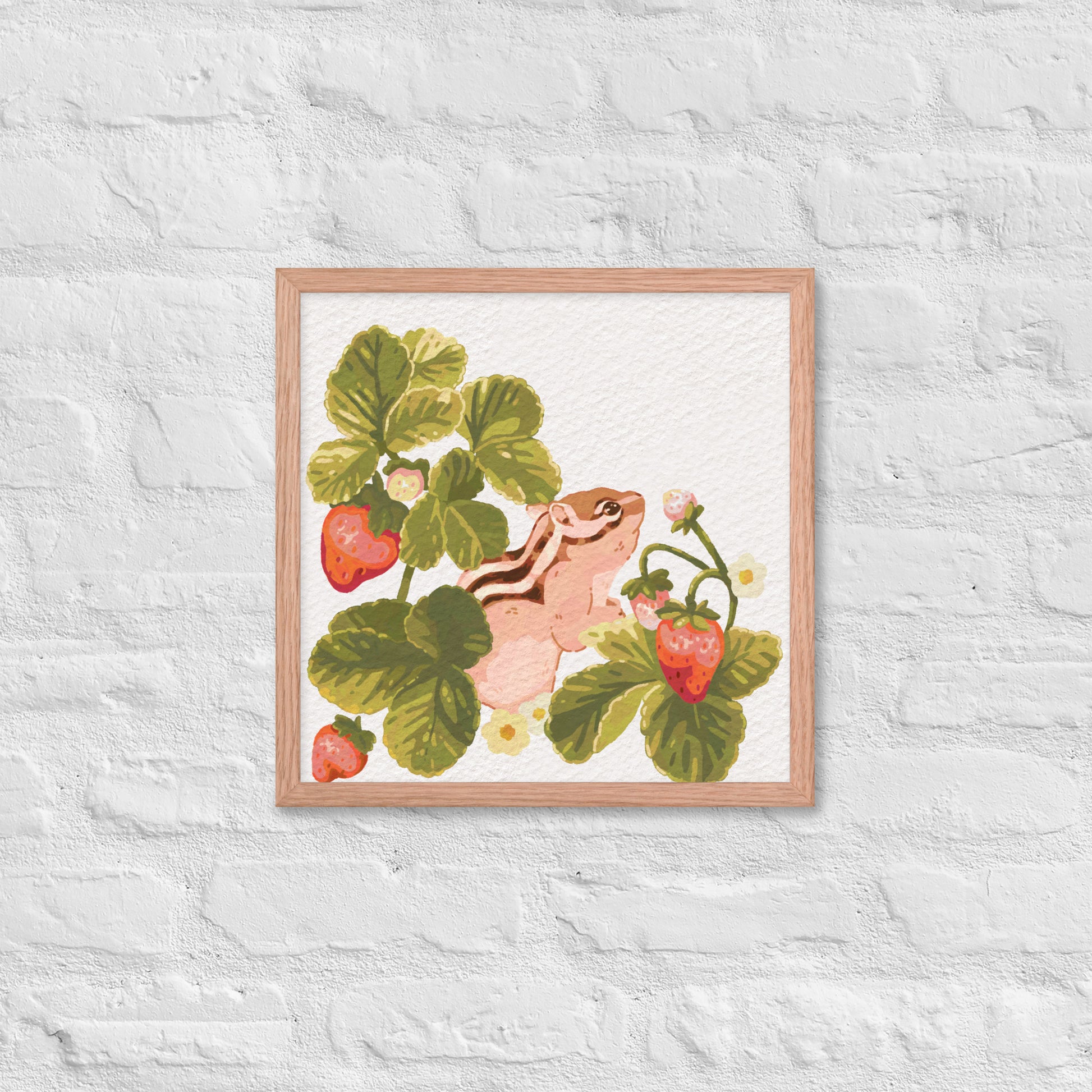 Framed artwork of a chipmunk among strawberry plants on a textured white wall.