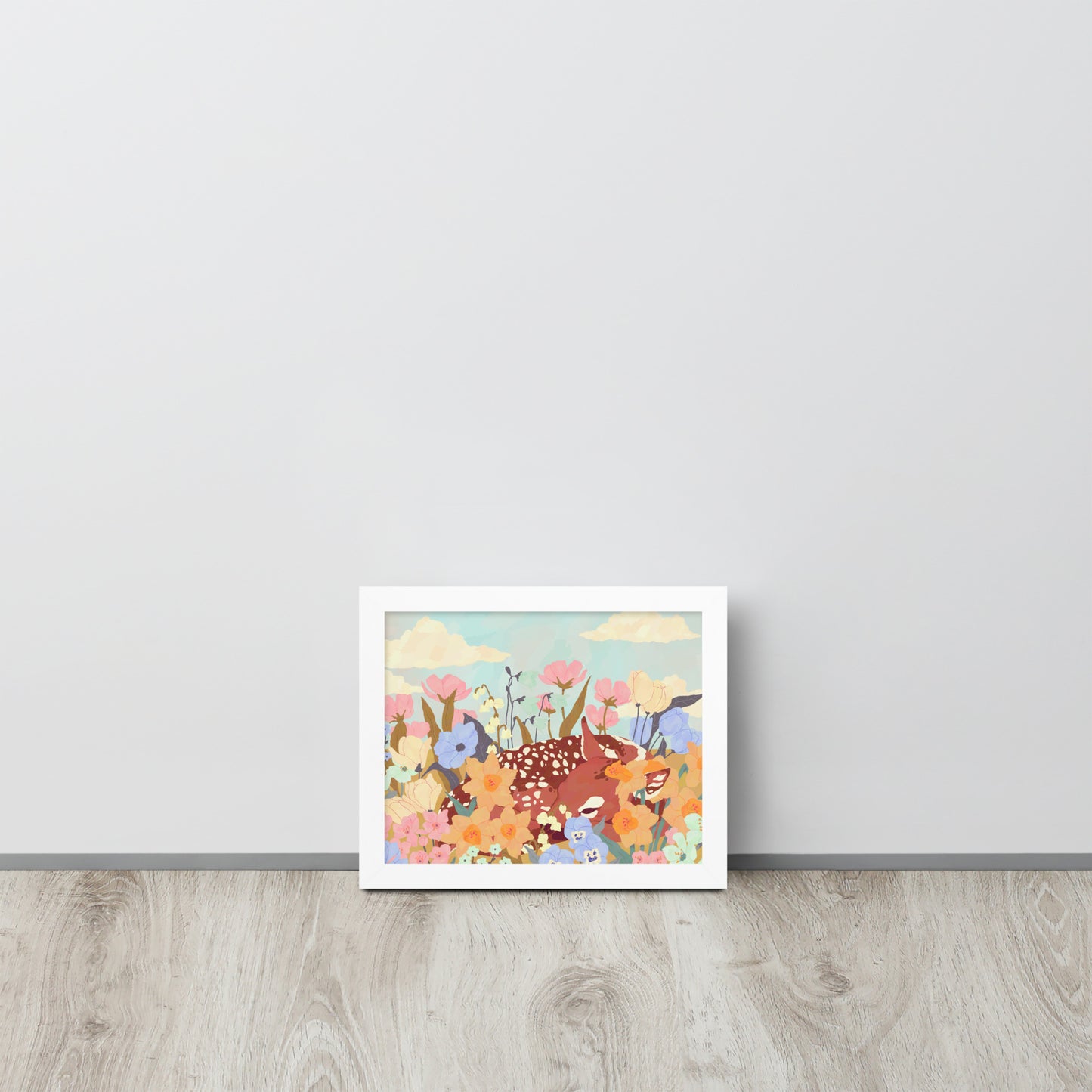 Framed artwork of a deer among flowers on a light gray wall.