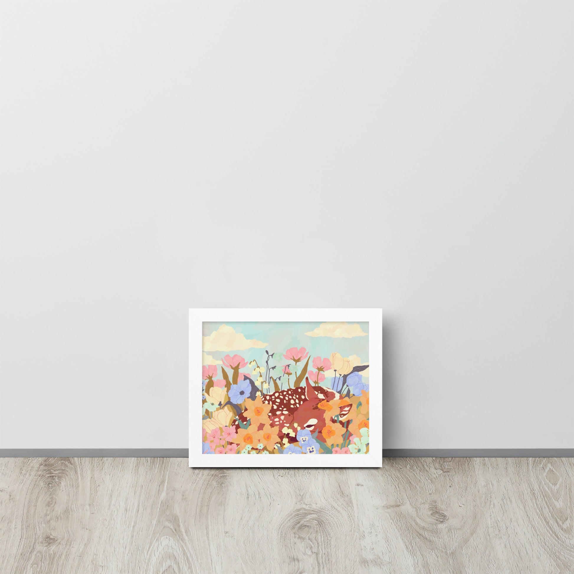 Framed artwork of a deer among flowers on a light gray wall.