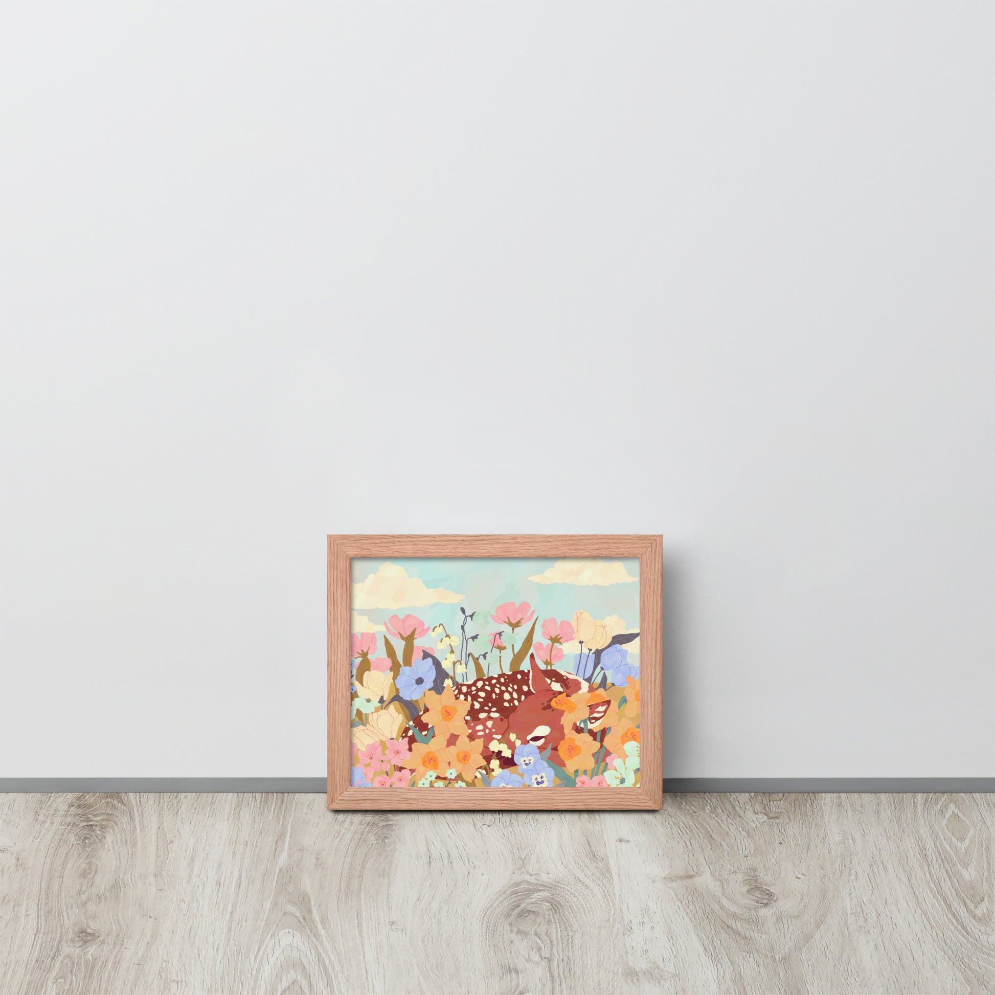 Framed artwork of a deer among flowers on a light gray wall.