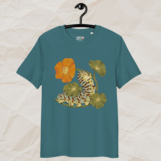 Teal t-shirt with caterpillar and flower design on a hanger against a beige background